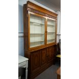 AN OAK TWO SECTION GLASS DOOR BOOKCASE, TWO GLASS DOORS, 'ONE SLIDING', LOWER SECTION ALSO HAS ONE