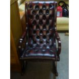 A MAHOGANY REGENCY STYLE ROCKING ARMCHAIR, BUTTON UPHOLSTERED IN DARK TAN HIDE
