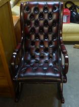 A MAHOGANY REGENCY STYLE ROCKING ARMCHAIR, BUTTON UPHOLSTERED IN DARK TAN HIDE