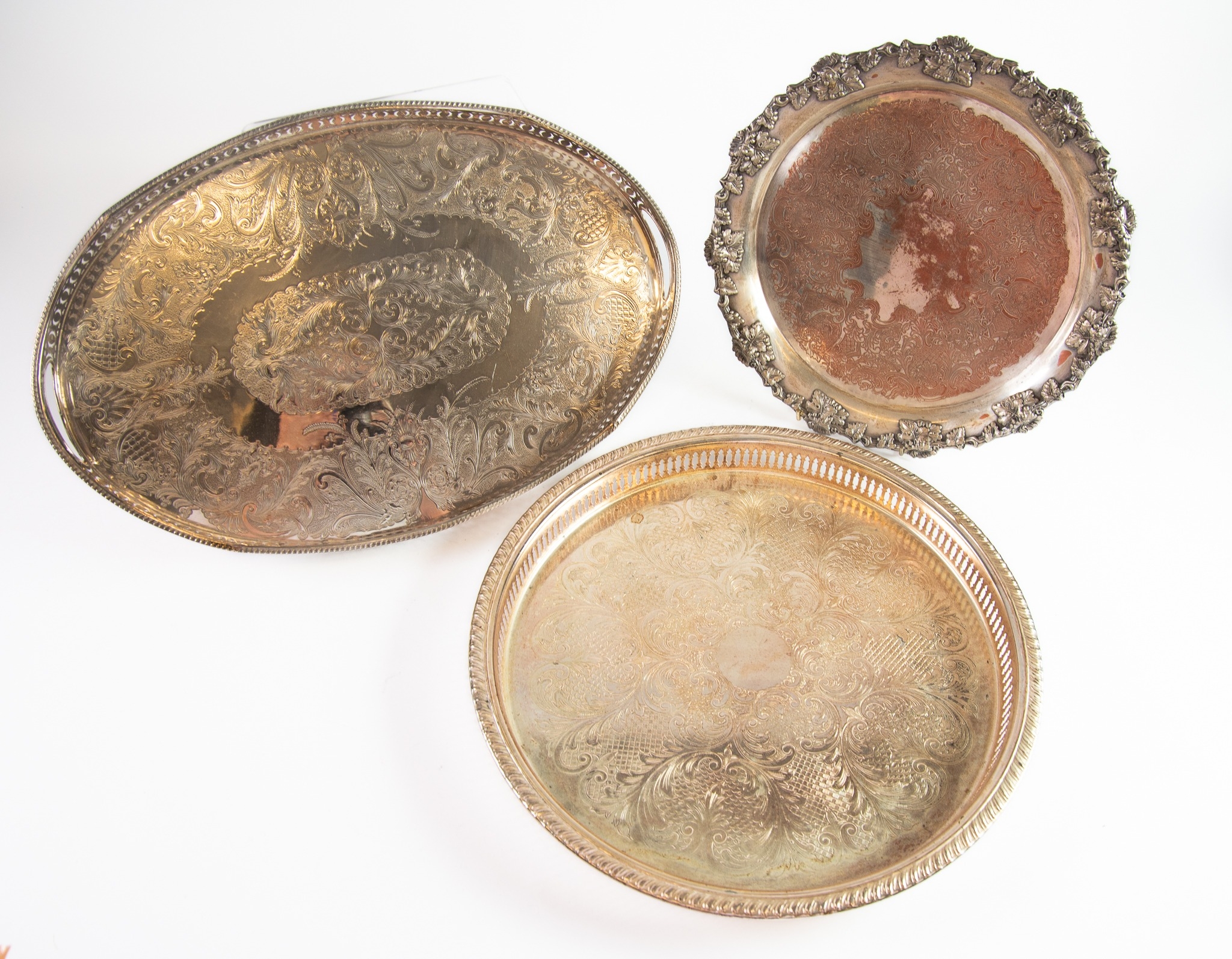 THREE ELECTROPLATED TRAYS, one, oval galleried with chased centre, 18” x 12” (45.7cm x 30.5cm),