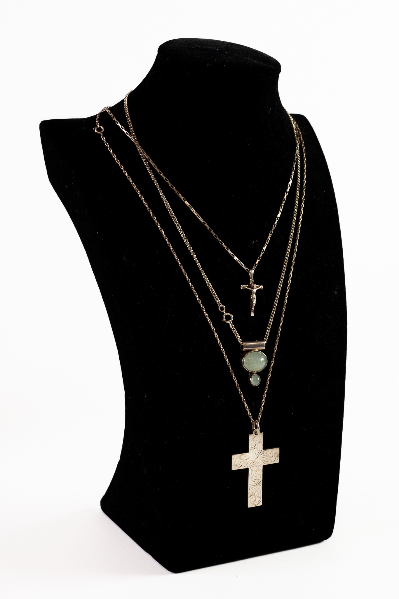THREE SILVER CHAIN NECKLACES, one with engraved cross pendant, one with a crucifix pendant adn the
