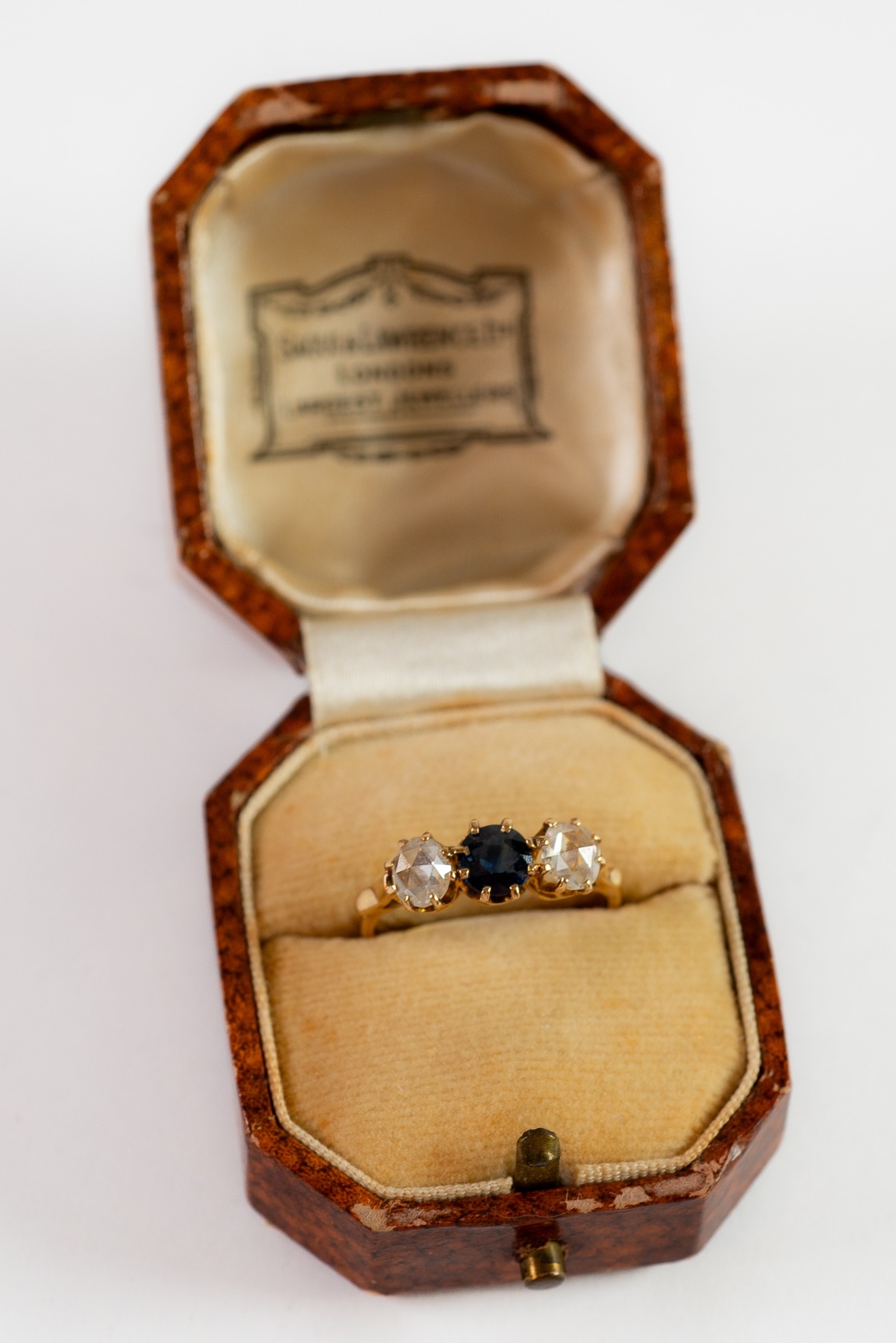 GOLD COLOUR METAL (no carat mark) RING SET WITH A SAPPHIRE BETWEEN TWO ROSE-CUT DIAMONDS, 2.6 gms