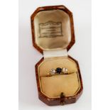 GOLD COLOUR METAL (no carat mark) RING SET WITH A SAPPHIRE BETWEEN TWO ROSE-CUT DIAMONDS, 2.6 gms