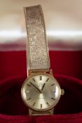 LADY'S OMEGA WRIST WATCH with gold-plated case, circular silvered dial with batons and 9ct gold