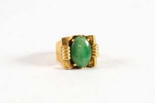 CHINESE GOLD RING set with an oval green jade in an Art Deco cup setting, broad shank, 8.8gms gross,