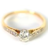 18ct GOLD RING, with a round brilliant cut diamond in eight claw setting, two tiny diamonds to