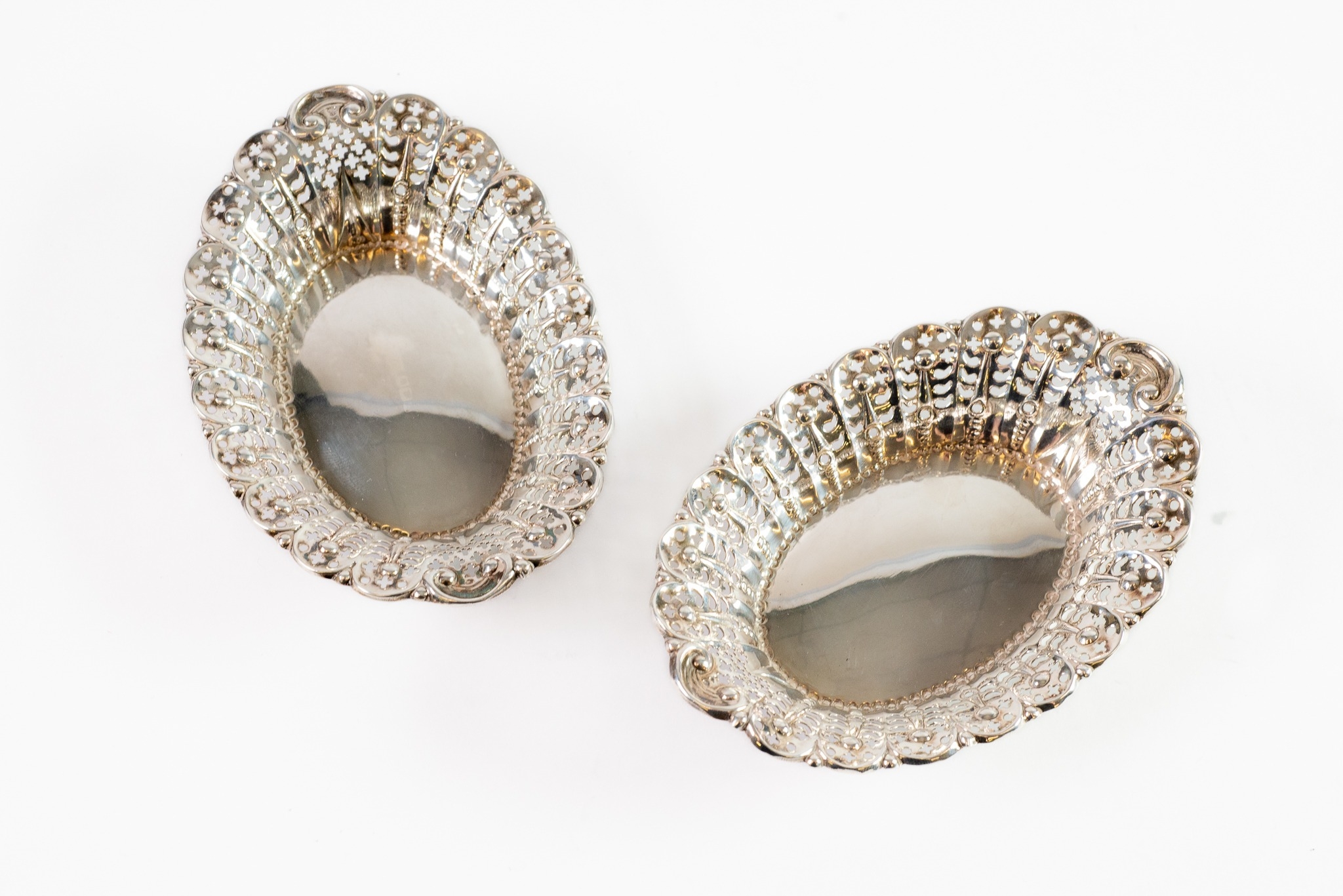 LATE VICTORIAN PAIR OF PIERCED SILVER SWEET MEAT DISHES BY JAMES DIXON & SONS, each of oval form