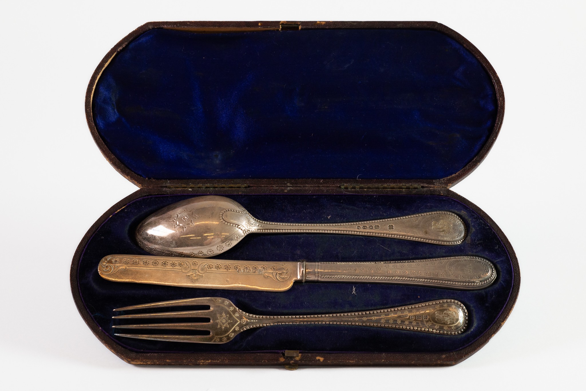 CASED VICTORIAN AND LATER THREE PIECE SILVER CHILD’S CUTLERY SET, the spoon, London 1872, the silver