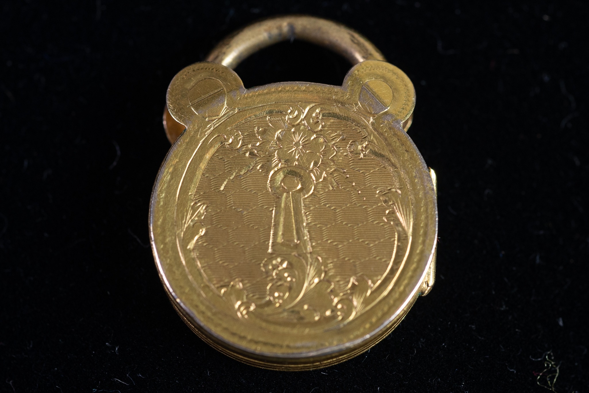 VICTORIAN WELL ENGRAVED CIRCULAR PADLOCK PATTERN LOCKET with gold back and front, 3/4" diameter (