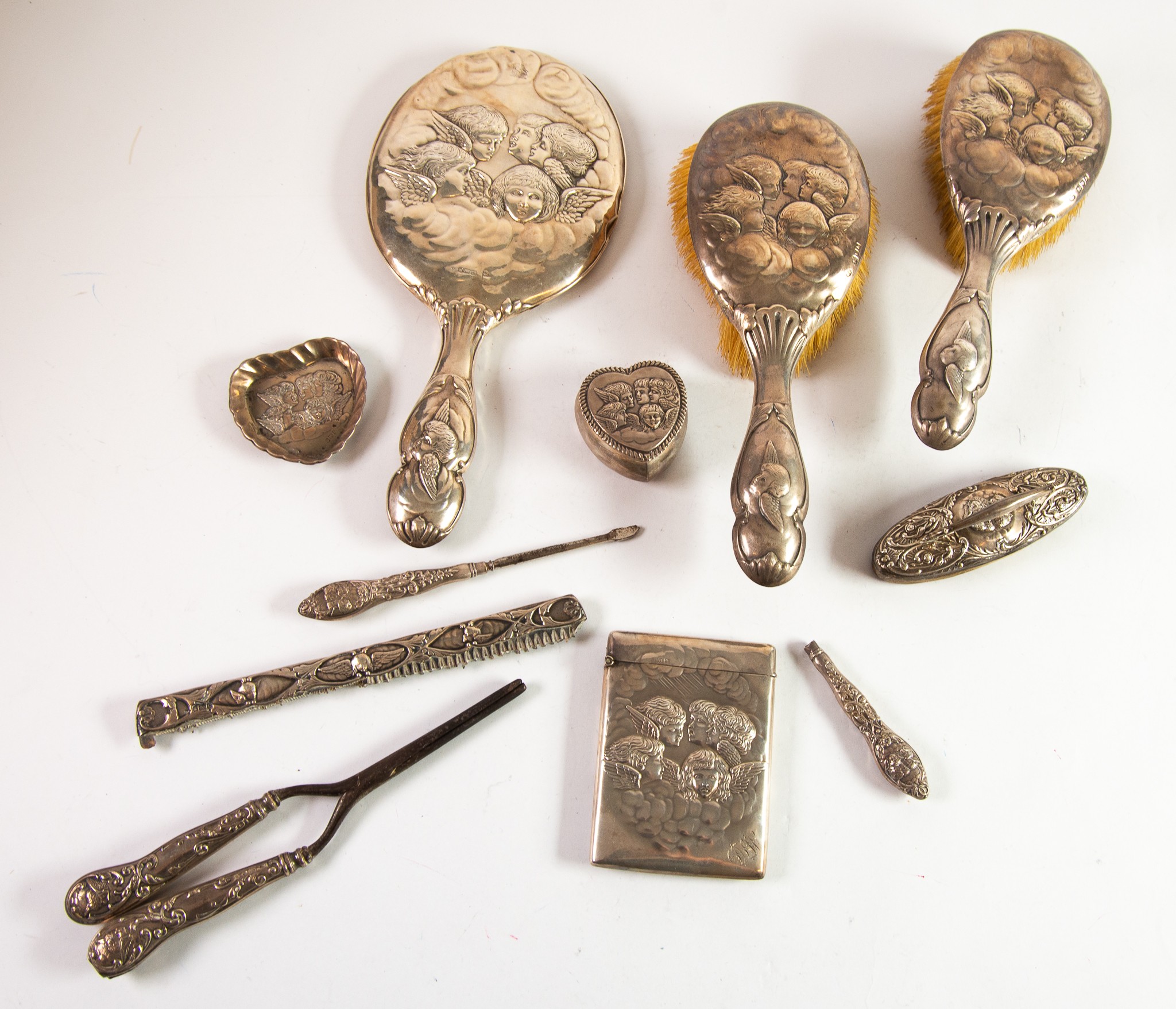 ELEVEN PICES OF SILVER EMBOSSED WITH REYNOLD’S ANGELS, comprising: DRESSING TABLE HAND MIRROR,