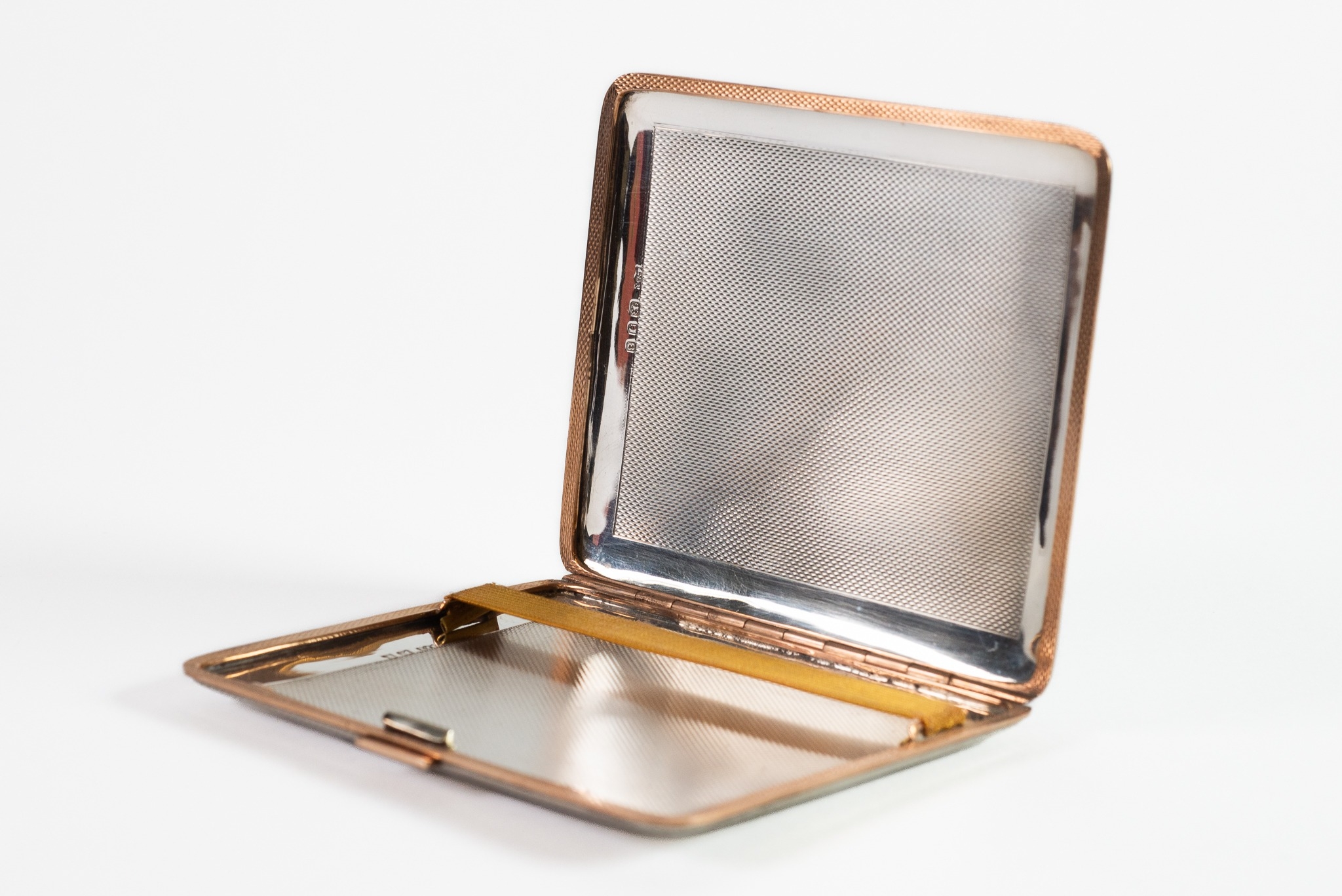 GEORGE VI ENGINE TURNED SILVER POCKET CIGARETTE CASE, with silver gilt edging and press opener, 4” x
