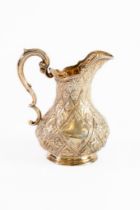 VICTORIAN EMBOSSED SILVER MILK JUG BY MARTIN, HALL & Co, of footed baluster form with fancy double