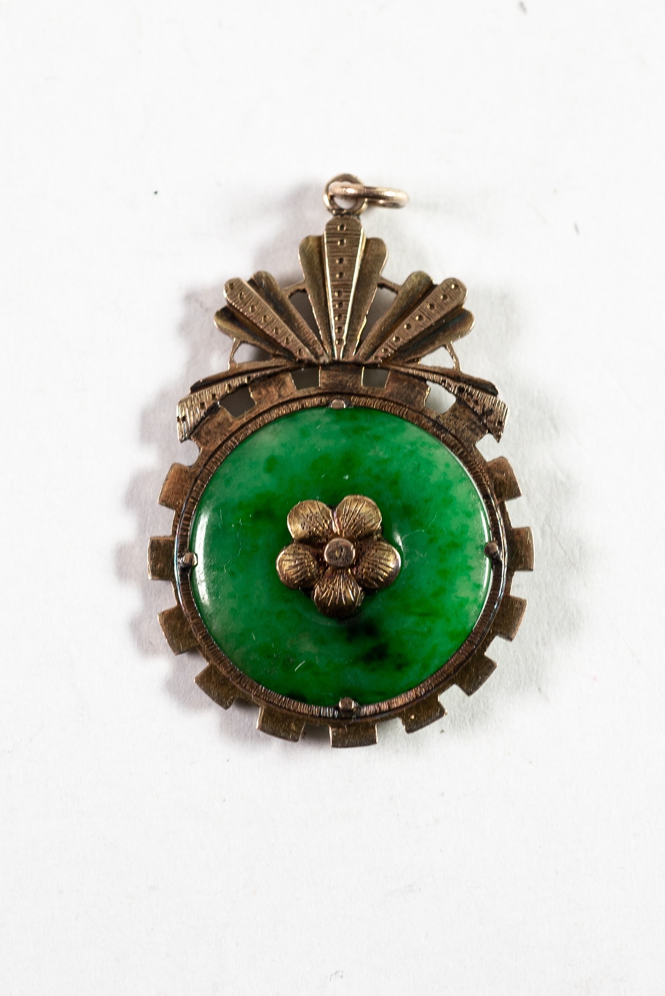 CHINESE GOLD PENDANT, claw set with a disc of green jade with gold flower to the centre on each