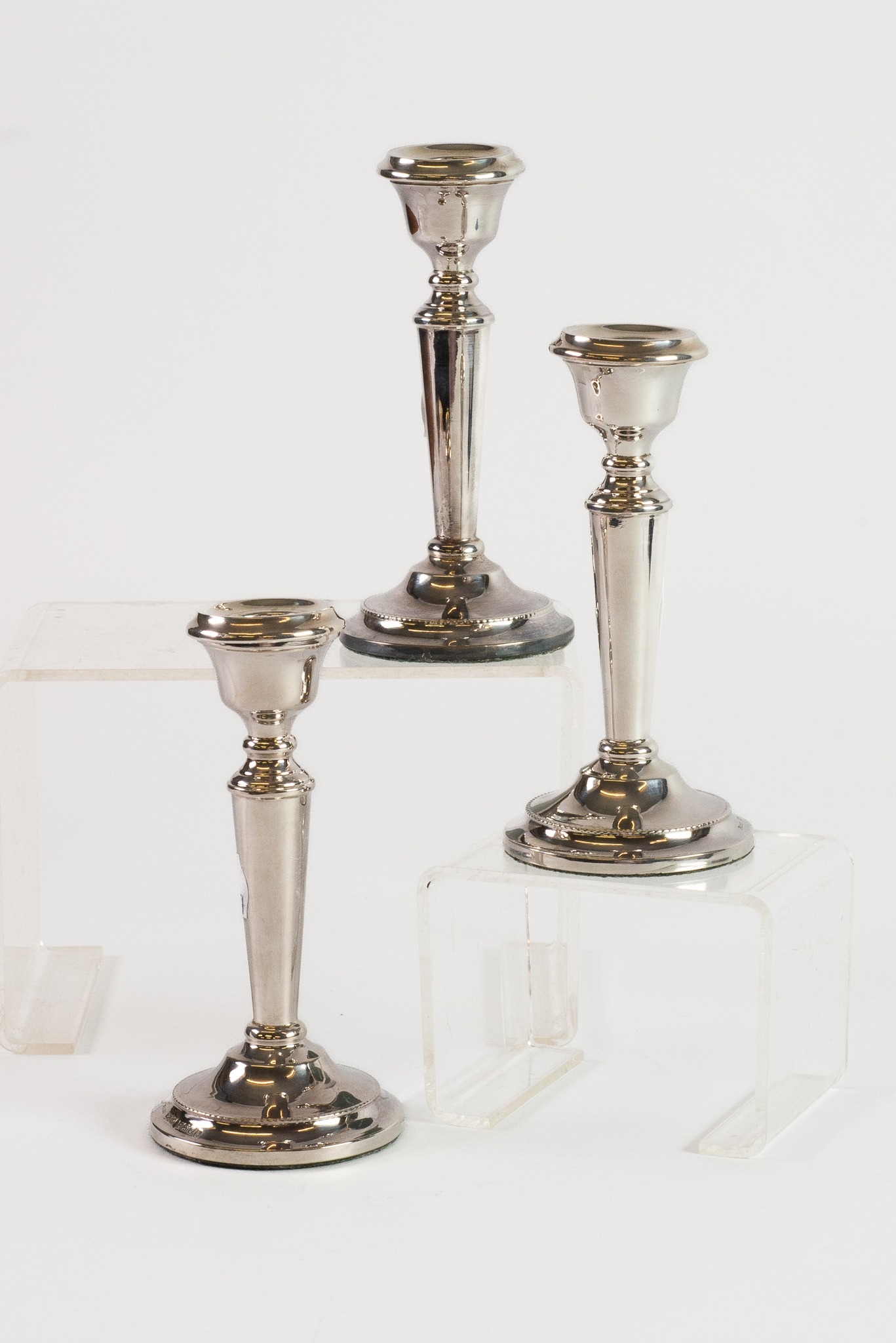 SET OF THREE WEIGHTED SILVER DRESSING TABLE CANDLESTICKS, each of tapering form with beaded border