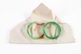 CHINESE GREEN JADE COLOURED PEKING GLASS BANGLE, in original paper wrapper and a SIMILAR BANGLE, (2)