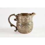 EDWARD VII EMBOSSED SILVER CREAM JUG, with fancy scroll handle and plain moulded border, decorated