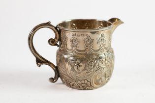 EDWARD VII EMBOSSED SILVER CREAM JUG, with fancy scroll handle and plain moulded border, decorated