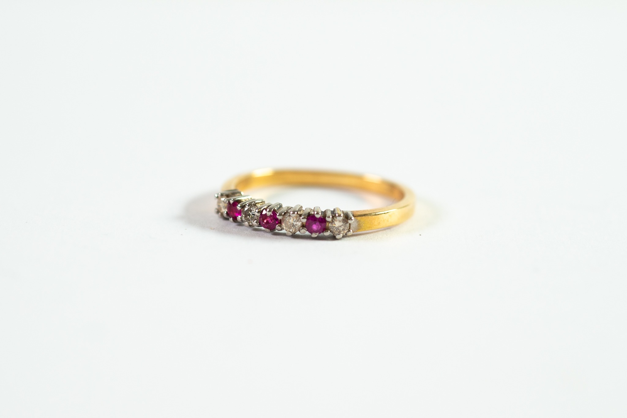 18ct GOLD RING set with a row of four small diamonds and three small rubies, 2.6gms