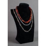 SINGLE STRAND NECKLACE OF GRADUATED AND FACETED RED AMBER COLOURED BEADS; A SINGLE STRAND NECKLACE