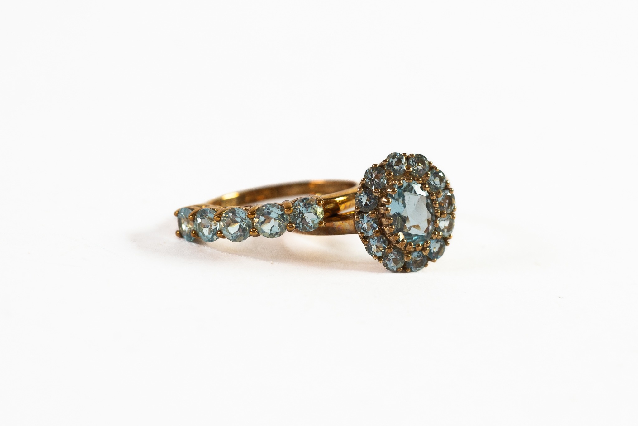 9ct GOLD OVAL CLUSTER RING set with centre oval pale blue stone and surround of small pale blue