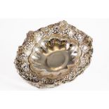 VICTORIAN EMBOSSED AND PIERCED SILVER SWING HANDLED CAKE BASKET, of circular footed form with floral