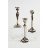 SET OF THREE WEIGHTED SILVER CANDLESTICKS, each of tapering form with beaded border and circular