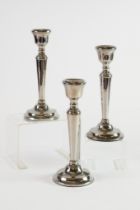 SET OF THREE WEIGHTED SILVER CANDLESTICKS, each of tapering form with beaded border and circular