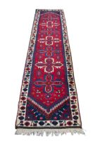 TURKISH DOSEMEALTI RUNNER, with a row of seven propeller shaped medallions on a wine red field, with