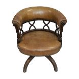 An Edwardian mahogany and leather tub shaped swivel desk chair