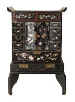 A Japanese Meiji period black lacquer cabinet on stand