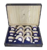 A cased Aynsley set of six coffee cups and silver an enamel spoons