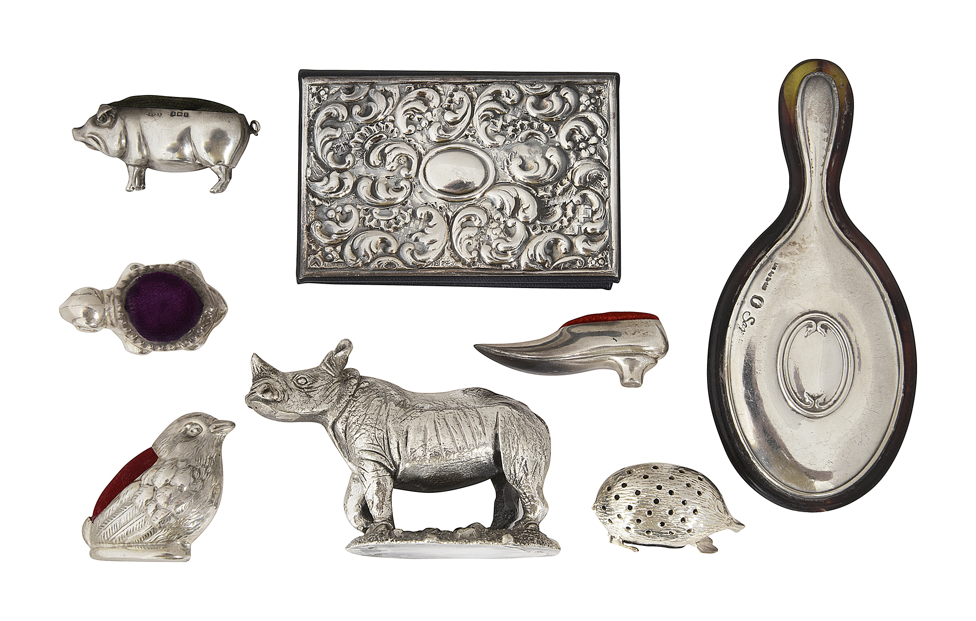 A collection of novelty silver pincushions and other items