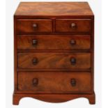 An early 19th century figured mahogany miniature chest of drawers
