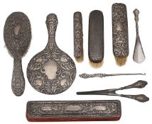 An Edwardian embossed silver hand mirror, clothes brushes and other items