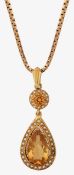 A Edwardian style citrine drop pendant suspended on a chain