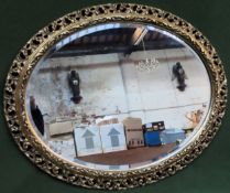 20th century gilded and piercework decorated oval bevelled wall mirror. Approx. 72cms x 58cms