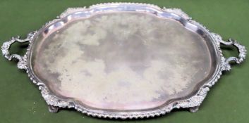 Large silver plated repousse decorated two handled serving tray on raised supports by S H & Co.