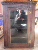 20th century carved fronted oak single door glazed wall mounting corner cabinet. Approx. 103cm H x