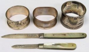 Three various hallmarekd silver napkin rings, plus two silver mother of pearl penknives