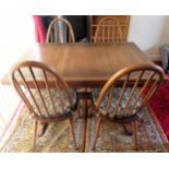 Ercol mid 20th century oak draw leaf dining table, plus four stickback chairs