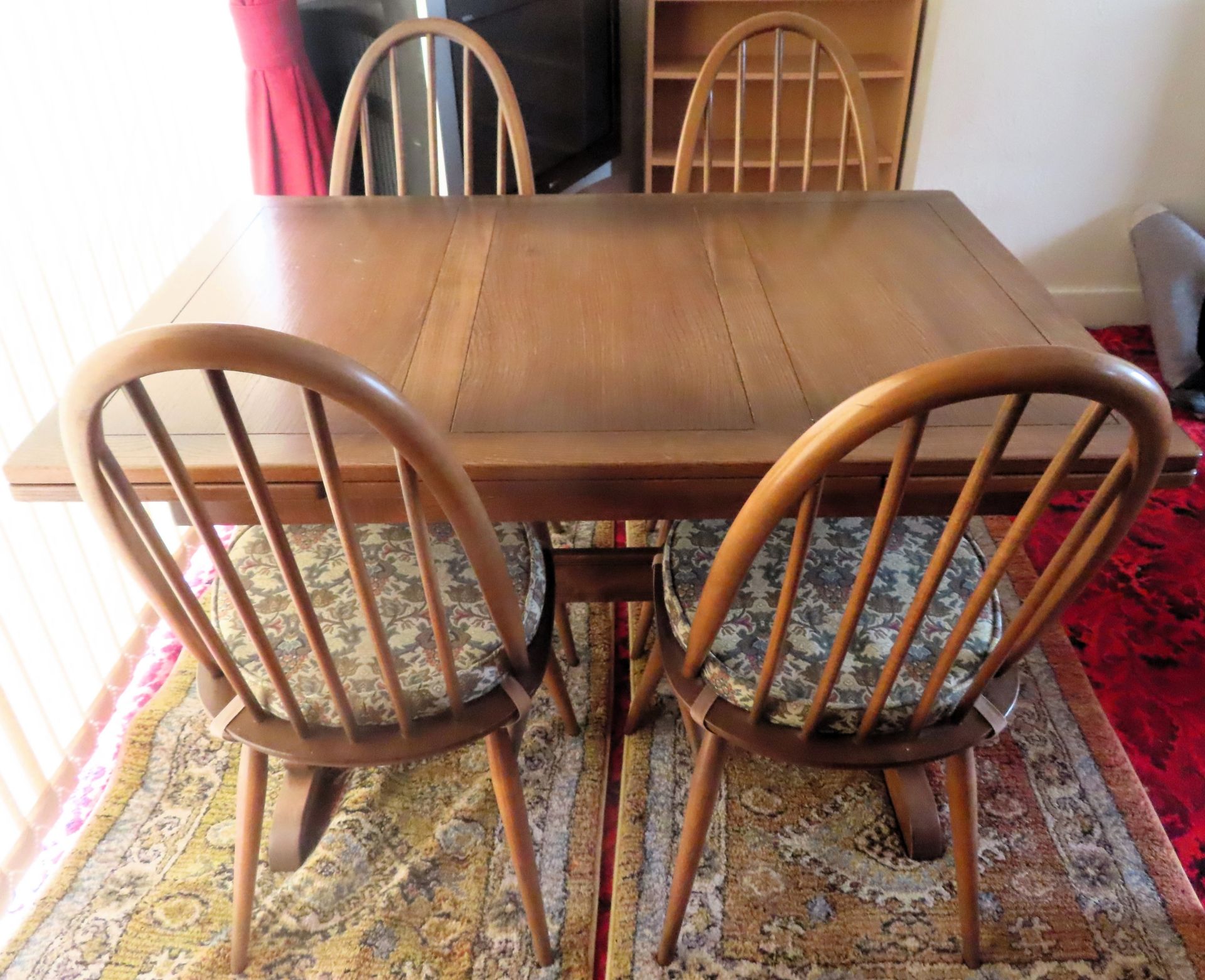 Ercol mid 20th century oak draw leaf dining table, plus four stickback chairs