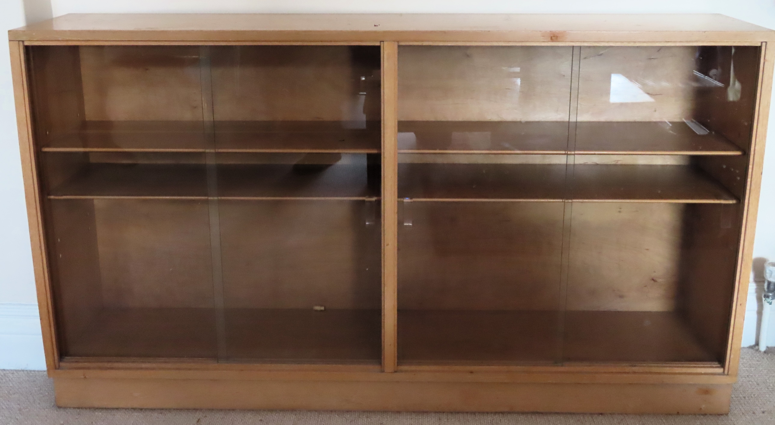 20th century light oak two door glazed bookcase. Approx. 77cm H x 137cm W x 26cm D Reasonable used