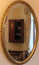 Gilded and piercework decorated oval bevelled wall mirror. Approx. 78 x 55cms reasonable used