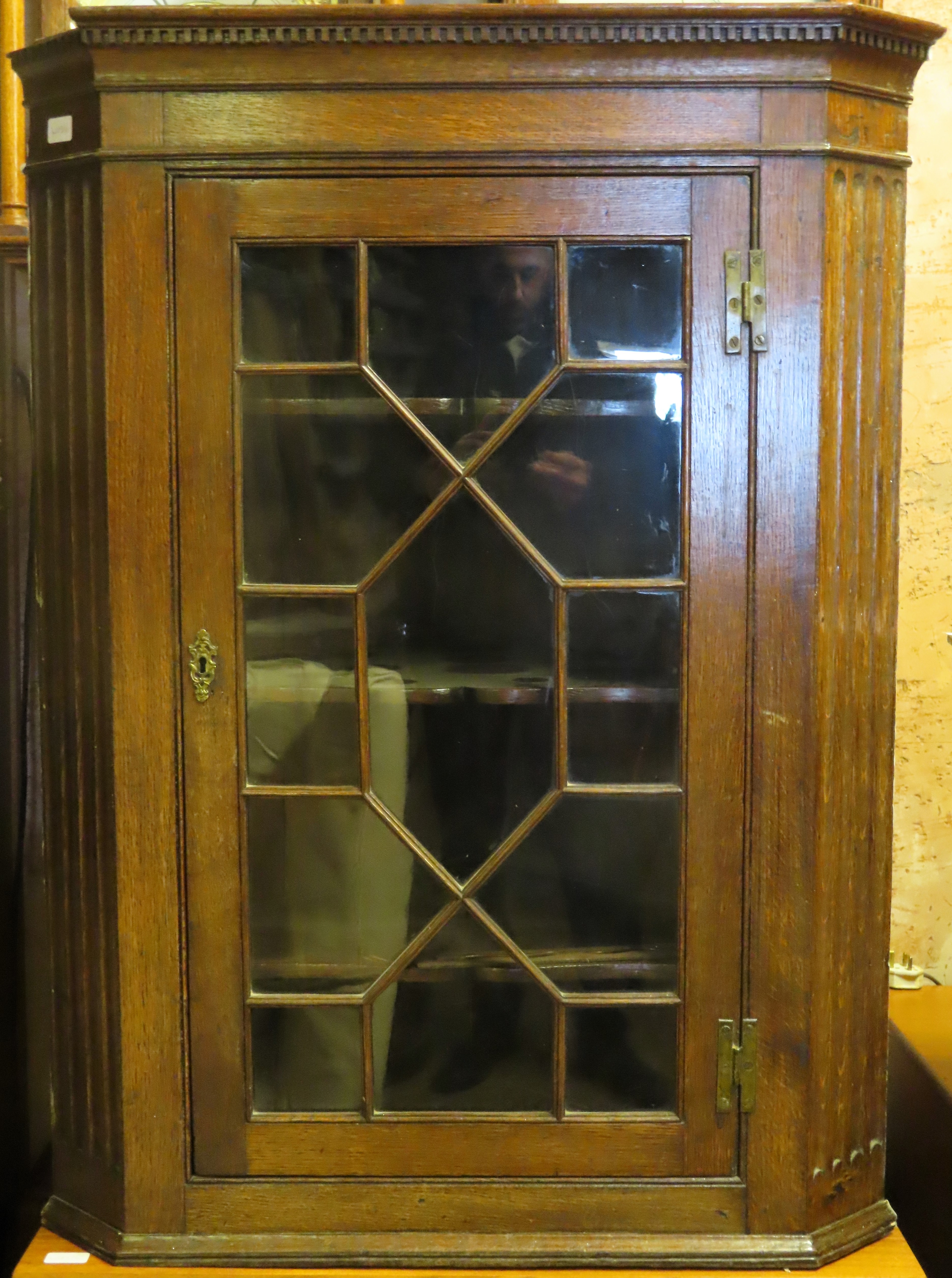 Early 20th century oak single door glazed corner cabinet. Approx. 109cm H x 82cm W x 49cm D Used