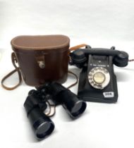 A black bakelite telephone together with a pair o Lieberman and Gortz binoculars.