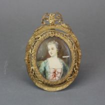 A gilt framed hand painted miniature of a young woman. H. 14.5cm W. 10cm.