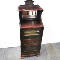 A carved mahogany perdonium on castors with an additional drop down two shelf compartment, 123 x