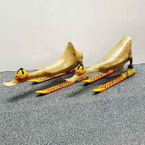 A pair of amusing wooden figures of ducks on skis, L. 44cm. One leg loose.