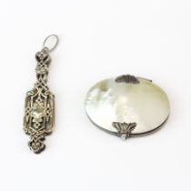 A Victorian mother of pearl and white metal folding magnifying glass, W. 5.5cm. Together with a