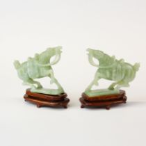 A pair of Chinese carved jade figures of horses with purpose made wooden bases, H. 8cm.